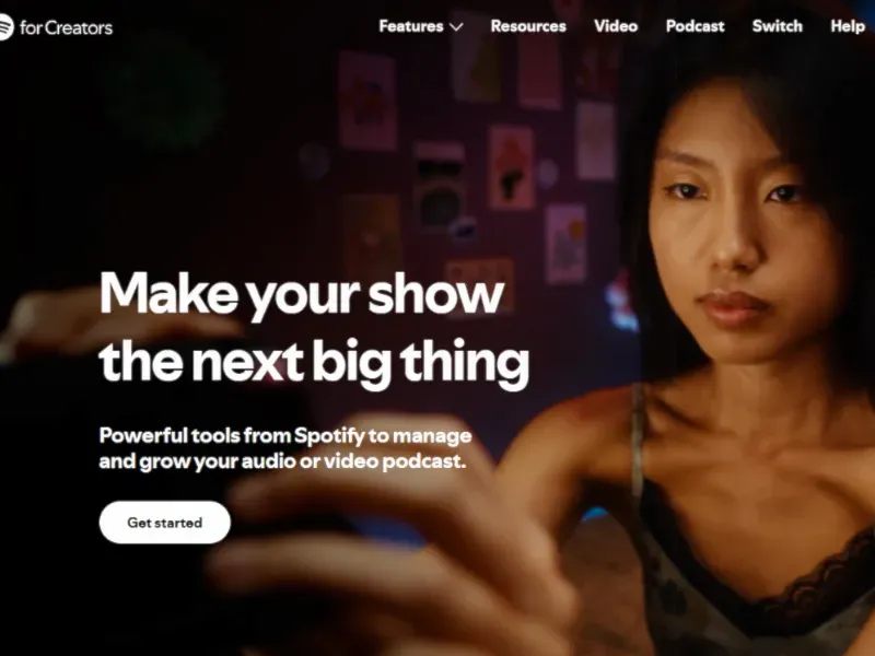 A person holds a phone, exploring Spotify's tools to enhance and grow their podcast, with colorful wall decorations in the background.